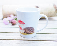 Laden Sie das Bild in den Galerie-Viewer, Elegante weiße Keramiktasse mit Tier- oder Blumenillustration, hochwertiger Druck, liebevoll gestaltet, Igel